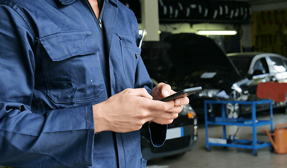 auto repair shop owner reviews his hibu website on a mobile device