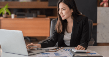 Professional accountant working on laptop and reports