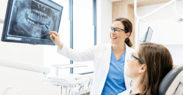 Dentist reviewing Xrays with patient in chair